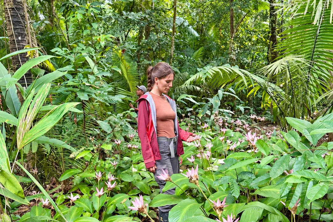 Viajera observando flores rosadas durante una excursión en la selva amazónica